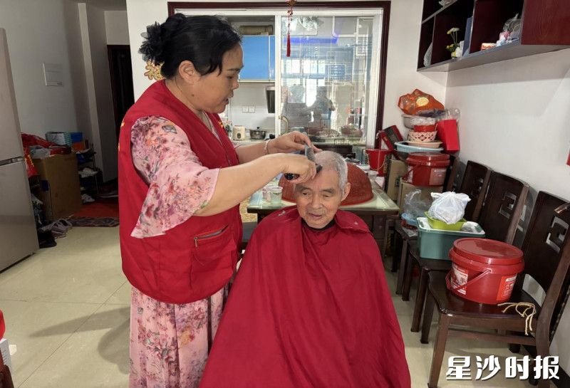 曹喜兰正在为杨海龙老人理发。社区供图