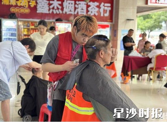 市民正在免费享受公益理发服务。