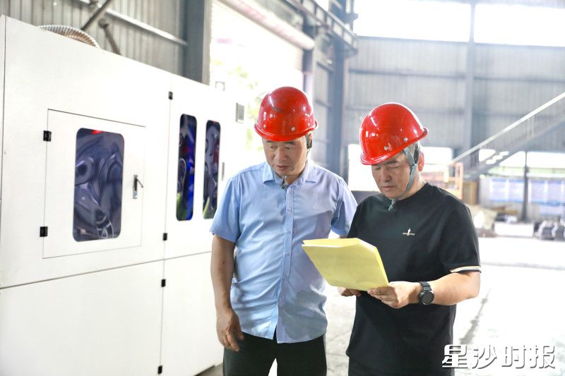 在出货质检区，涂建文（右一）仔细核对出货产品信息。周汝洁 摄