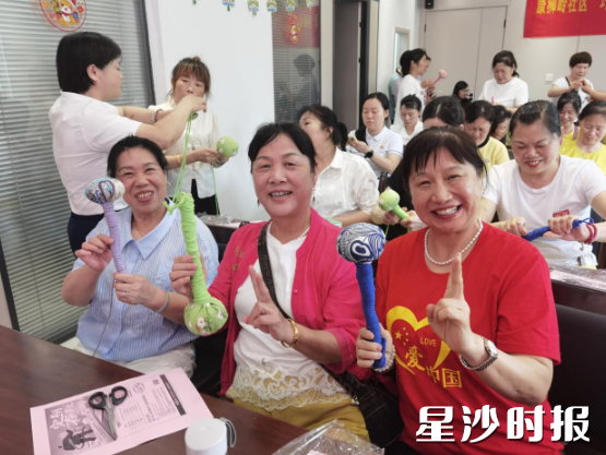 社区居民们展示自己制作的艾叶锤。