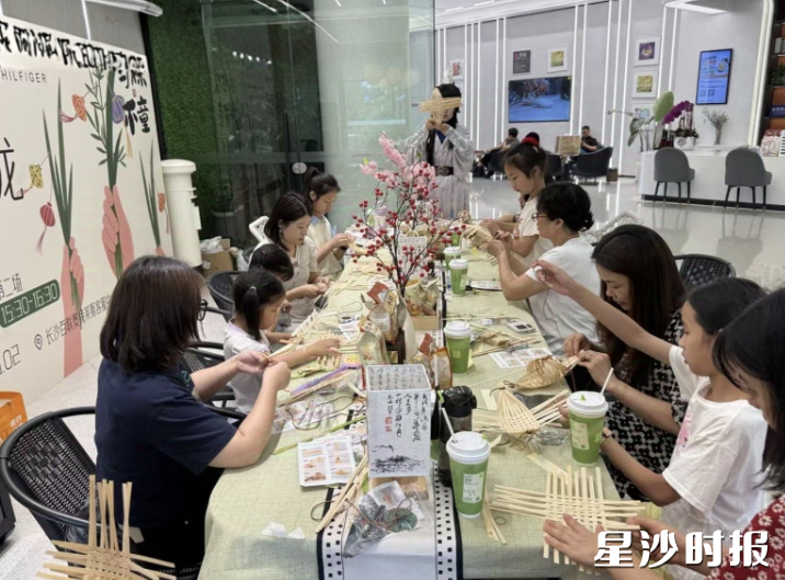 长沙百联奥莱推出端午主题活动，消费者们在购物之余体验包粽子、做手工。百联奥莱供图