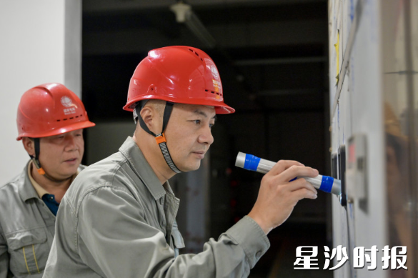 长沙市弘益高级中学考点，电力部门工作人员在考点值守。黄宇 摄
