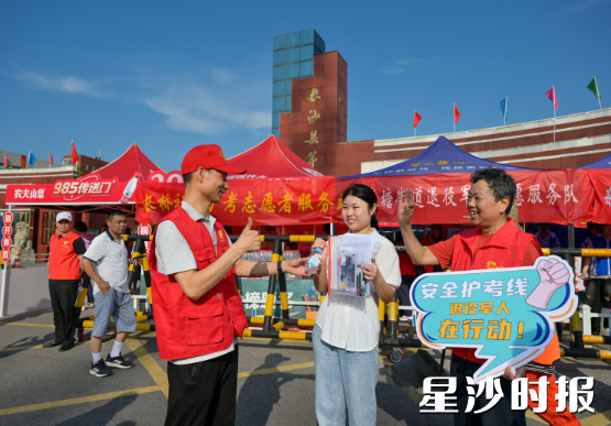 长沙县第一中学考点，老兵李铁流（右一）和退伍军人赵恢港（左一）为学子加油助力。黄宇 摄
