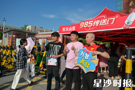 长沙县第一中学考点，“星沙好人”王楚建正在为考生送上祝福。黄宇 摄
