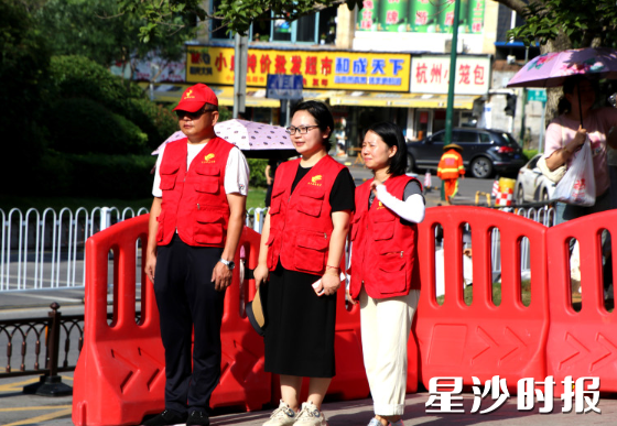 长沙市弘益高级中学考点，志愿者在烈日下坚守。余柱祥摄