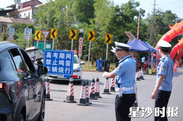 在长沙市明达高级中学考点附近，交警对路段进行管制，为考生营造一个良好的考试环境。