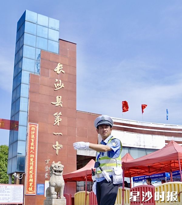 长沙县交警大队黄花中队指导员李辉在陪同儿子考试与护考之间，他选择坚守岗位，守护万千星沙考生。胡宇韬 摄