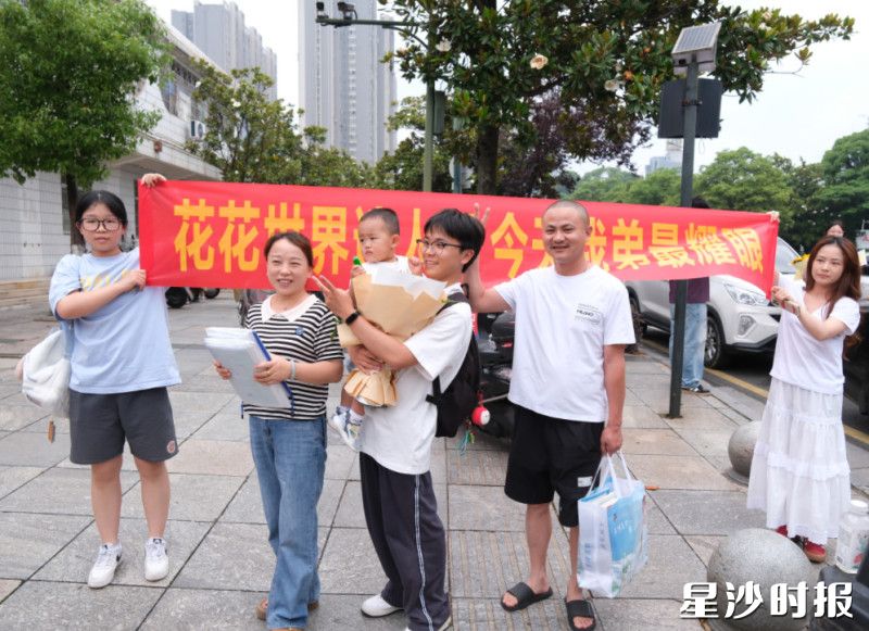 在长沙县实验中学考点，弟弟高考结束，姐姐拉横幅迎接：“花花世界迷人眼，今天我弟最耀眼！”