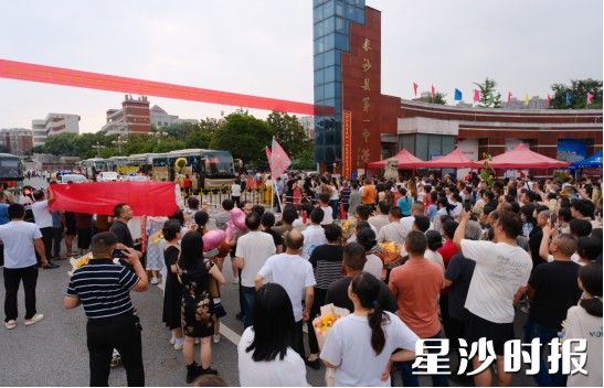 高考最后一天，众多家长早早守候在长沙县一中考场外，翘首以盼。他们或高举向日葵寓意“一举夺魁”，或身着旗袍象征“旗开得胜”，或以鲜花、横幅表达心意，用种种充满仪式感的方式，为即将结束征途的孩子们讨个好彩头，送上最深切的祝福与支持。曹向东 摄