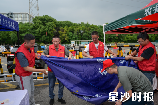 高考落幕，校园外恢复了宁静。泉塘街道退役军人志愿服务队的队员们正井然有序地清理现场，他们利落地捡拾散落在地的宣传单、矿泉水瓶；仔细归位被挪动的锥桶和隔离带；麻利地整理助考点帐蓬。他们动作干净利落，配合默契，用无声的行动，迅速而高效地抚平了高考后的喧嚣，也为这场牵动人心的大考画上了一个利落而温暖的句点。黄宇 摄