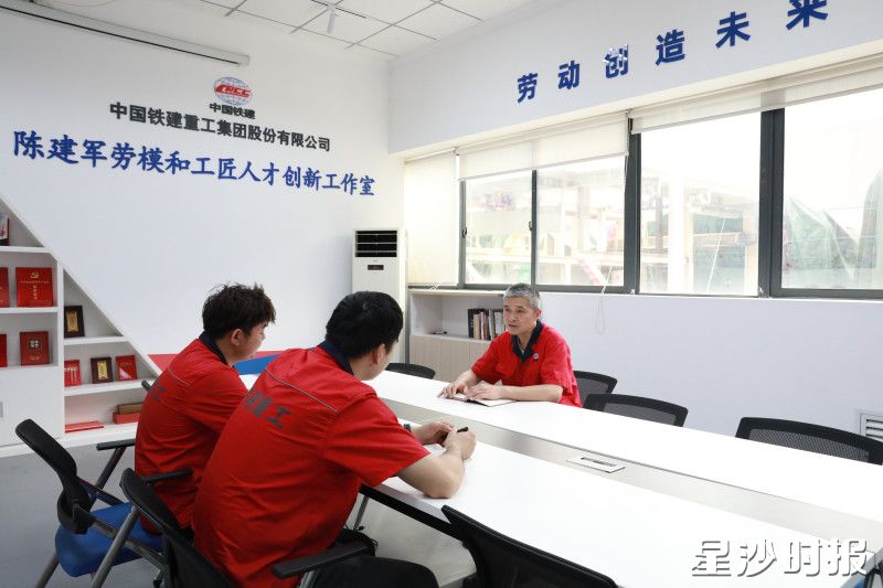 在工作室，陈建军与工友交流当日工作情况。
