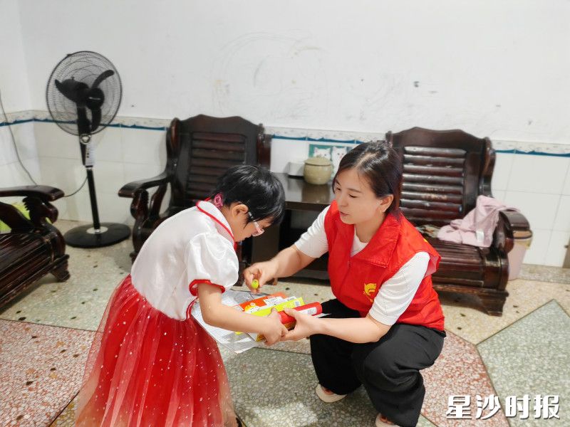 志愿者将爱心文具送到学生家中。