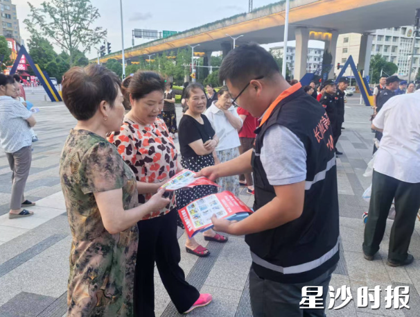 工作人员在活动现场派发安全宣传手册。 工作人员在活动现场派发安全宣传手册。