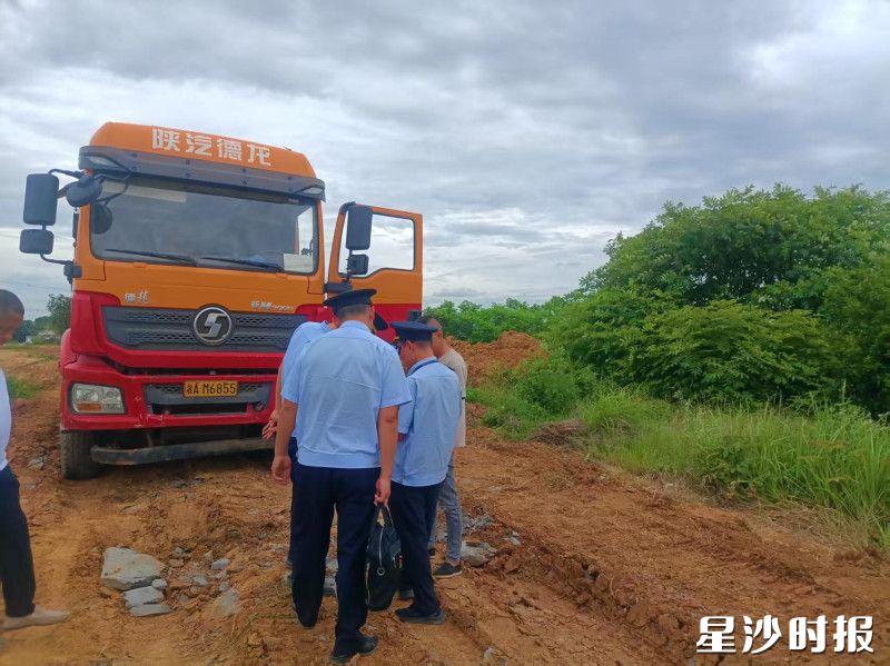一辆未取得运输许可证的绿色货车在偏僻路段偷倒建筑垃圾，被巡查人员当场查获。均为黄兴镇供图
