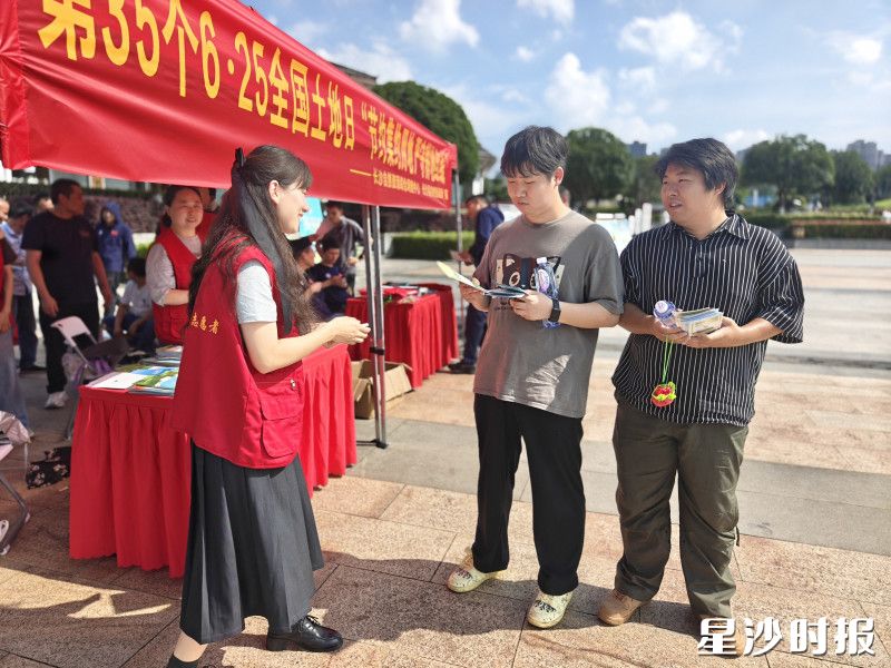 工作人员在活动现场给群众发放宣传资料。彭娴 摄