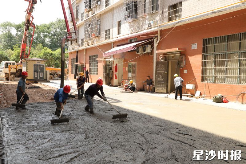 安沙镇水塘垸社区邓家坝安置小区老旧小区改造项目施工现场，工人们正忙着将泵车里的混凝土均匀地铺开。阮霖浩 摄