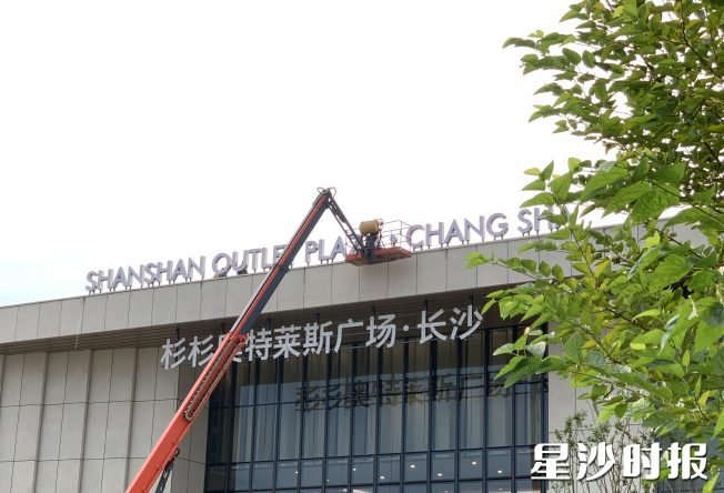 伴随着工人们将一个个字符安置完成，“长沙杉杉奥特莱斯广场”的白色标识在阳光下熠熠生辉。项目方供图