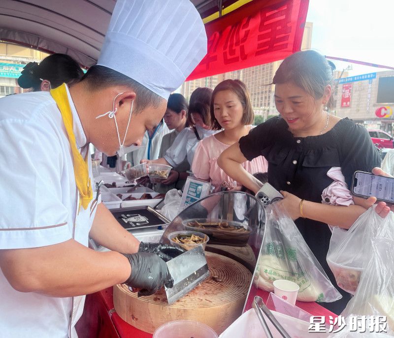 市民在星沙华天大酒店小吃摊前选购心仪的美食。王俊 摄 市民在星沙华天大酒店小吃摊前选购心仪的美食。王俊 摄