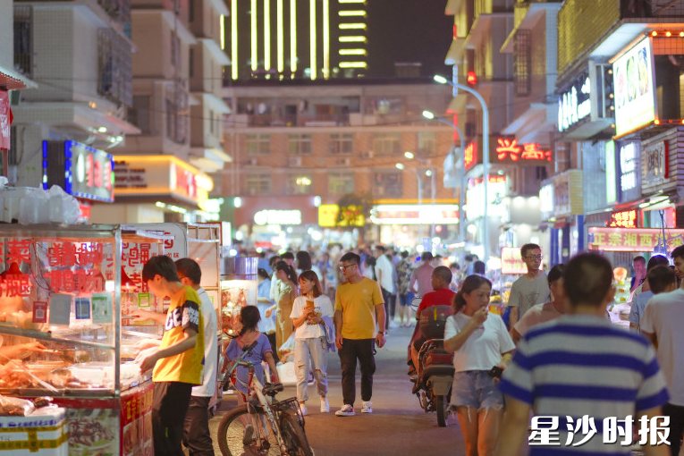 㮾梨街道龙华夜市华灯初上，人流如织。章帝 摄