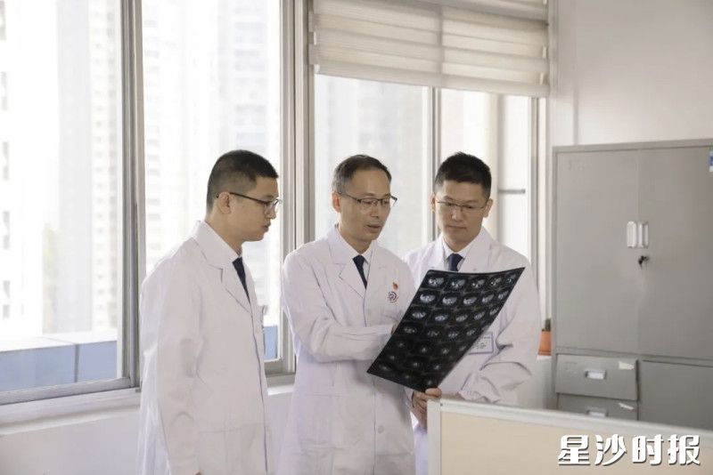 图为张军在跟同事沟通病情。 图为张军在跟同事沟通病情。