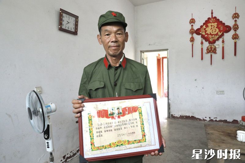 江检安向记者展示三等功荣誉奖状。周汝洁 摄