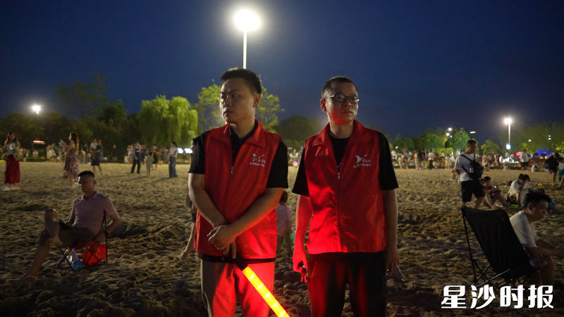 志愿者穿上反光条的马甲，手持荧光棒和手电筒，重点巡查水域周边、步道拐角等夜间危险区域。