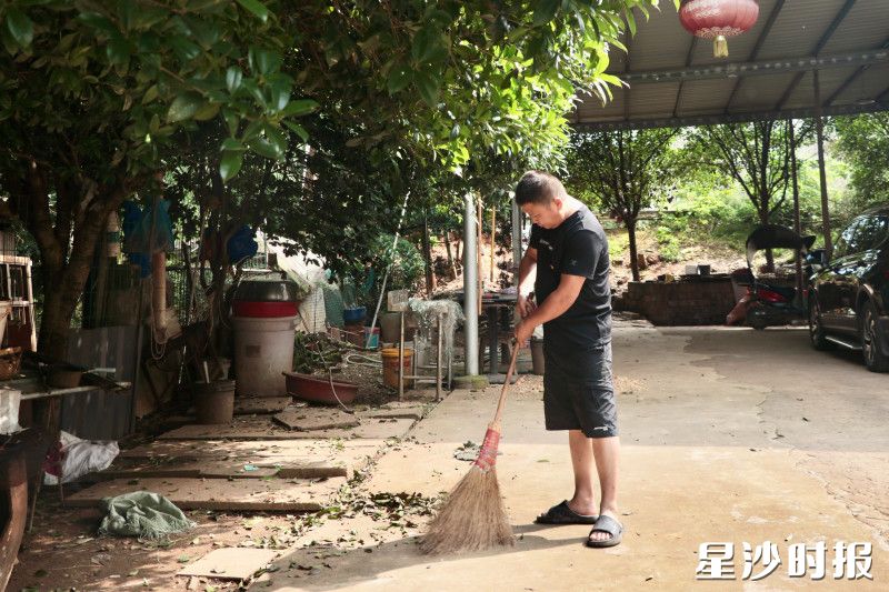 㮾梨街道檀木桥社区邻长卢山正在门前小院清扫落叶，归置小院卫生。赵佳慧 摄