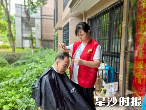 孟红云正在为邻里理发。