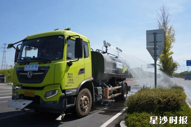 绿化智能洒水车驶过，水柱精准滋养灌木根部。均为杨欣雨 摄
