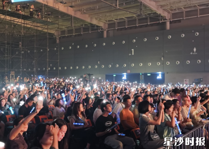 现场万名歌迷挥舞荧光棒，随节奏摇摆、呐喊。