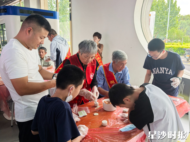 孩子们在志愿者和“好人”代表协助下制作冰皮月饼。长龙街道供图 孩子们在志愿者和“好人”代表协助下制作冰皮月饼。长龙街道供图