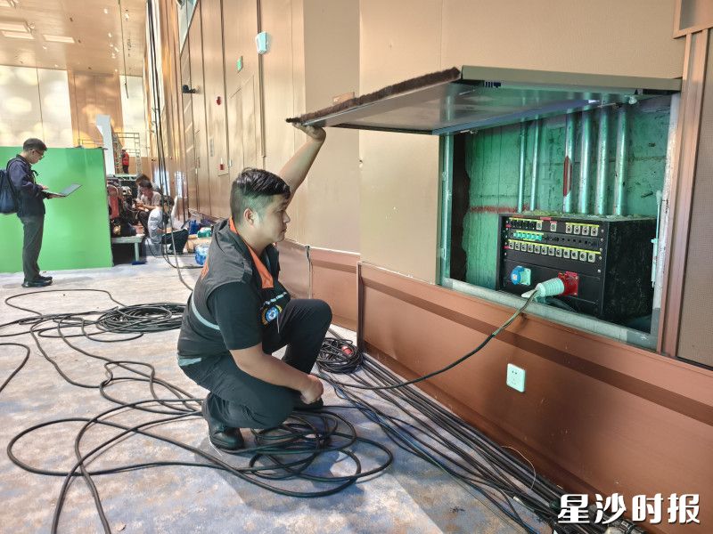 工作人员细致排查会场内每一处隐患。黄兴镇供图