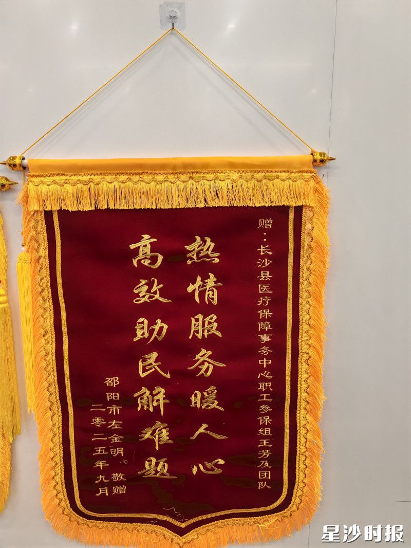 左先生向医保局王芳及其团队赠送锦旗表示感谢。医保局供图