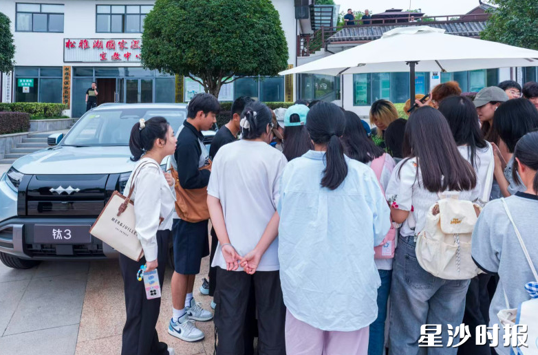 一展车旁挤满了市民和游客，正登记排队试乘。