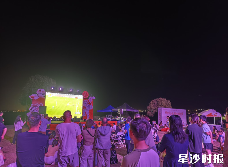 咖啡集市现场，LED大屏正在转播湘超联赛焦点对决，现场挤满了市民和游客。均为宋彬彬 摄