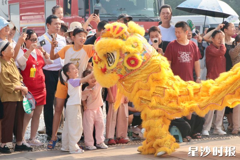 游客们与金狮欢乐互动。