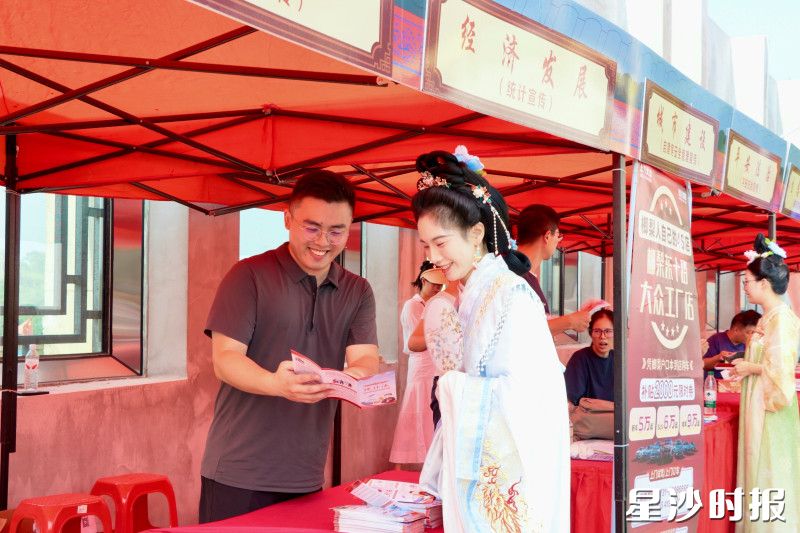 社会公益宣传集市上，志愿者向汉服爱好者宣传科普政策内容。