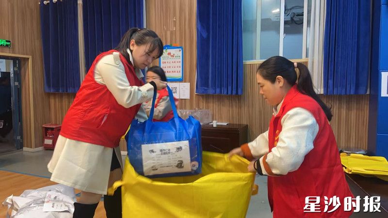 志愿者正在将爱心礼包整理装袋。