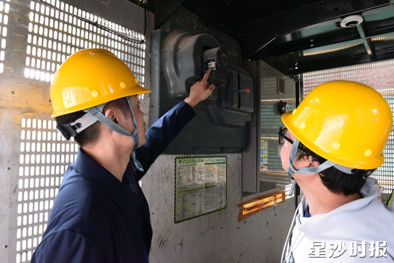 县住房城乡建设局工作人员在建筑工地检查电梯防坠装置参数。