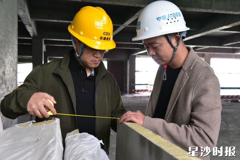 县住房城乡建设局工作人员在建筑工地检查防火岩棉板厚度。