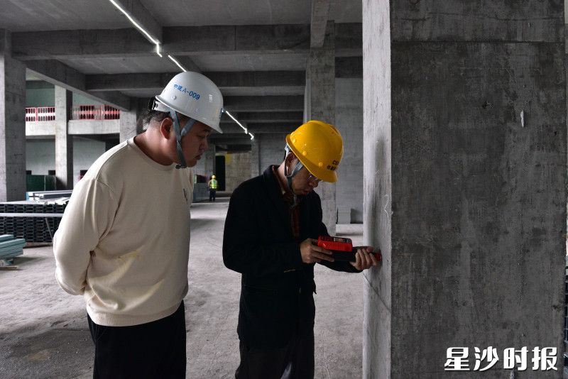 县住房城乡建设局工作人员在建筑工地检查混凝土性能。
