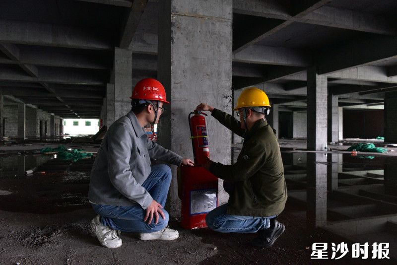 县住房城乡建设局工作人员在建筑工地检查灭火器情况。
