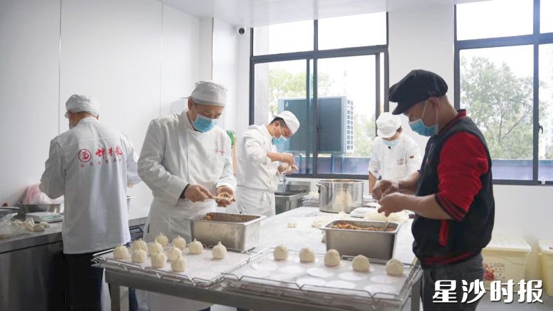 二楼生产车间内，面点师傅有序赶制各类包子。