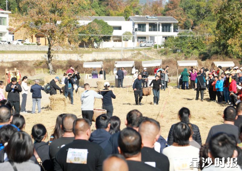 现场开展趣味农耕比赛，村民们肩挑稻谷，感受丰收喜悦。
