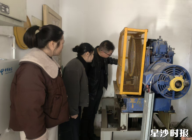 长沙县住房和城乡建设局工作人员在卧龙居小区检查电梯的主机。县住房城乡建设局供图