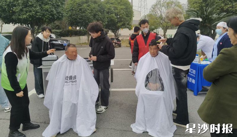 志愿者为市民理发。
