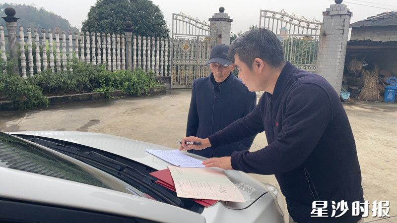 江背自然资源所工作人员把不动产权证送到村民手上。长沙县自然资源局供图