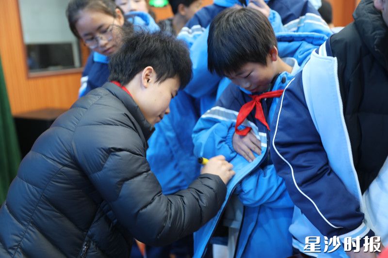 学生们纷纷排队找冠军要签名。均为文雅丽 摄