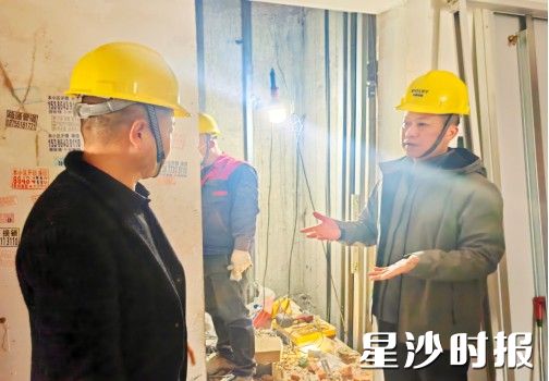 吴宏伟（右一）和物业负责人在电梯更新现场督促工作进度。均为街道供图
