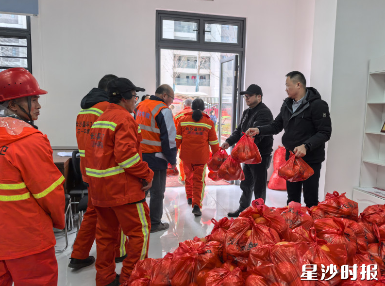 志愿者们细心地将脐橙送到环卫工人手中。通讯员供图